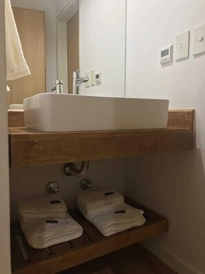Een haardroger, handdoeken, zeep, toiletpapier