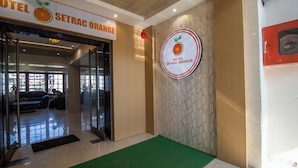 L’entrée de l’hôtel Setrac Orange, avec un tapis vert et une enseigne au-dessus de la porte.