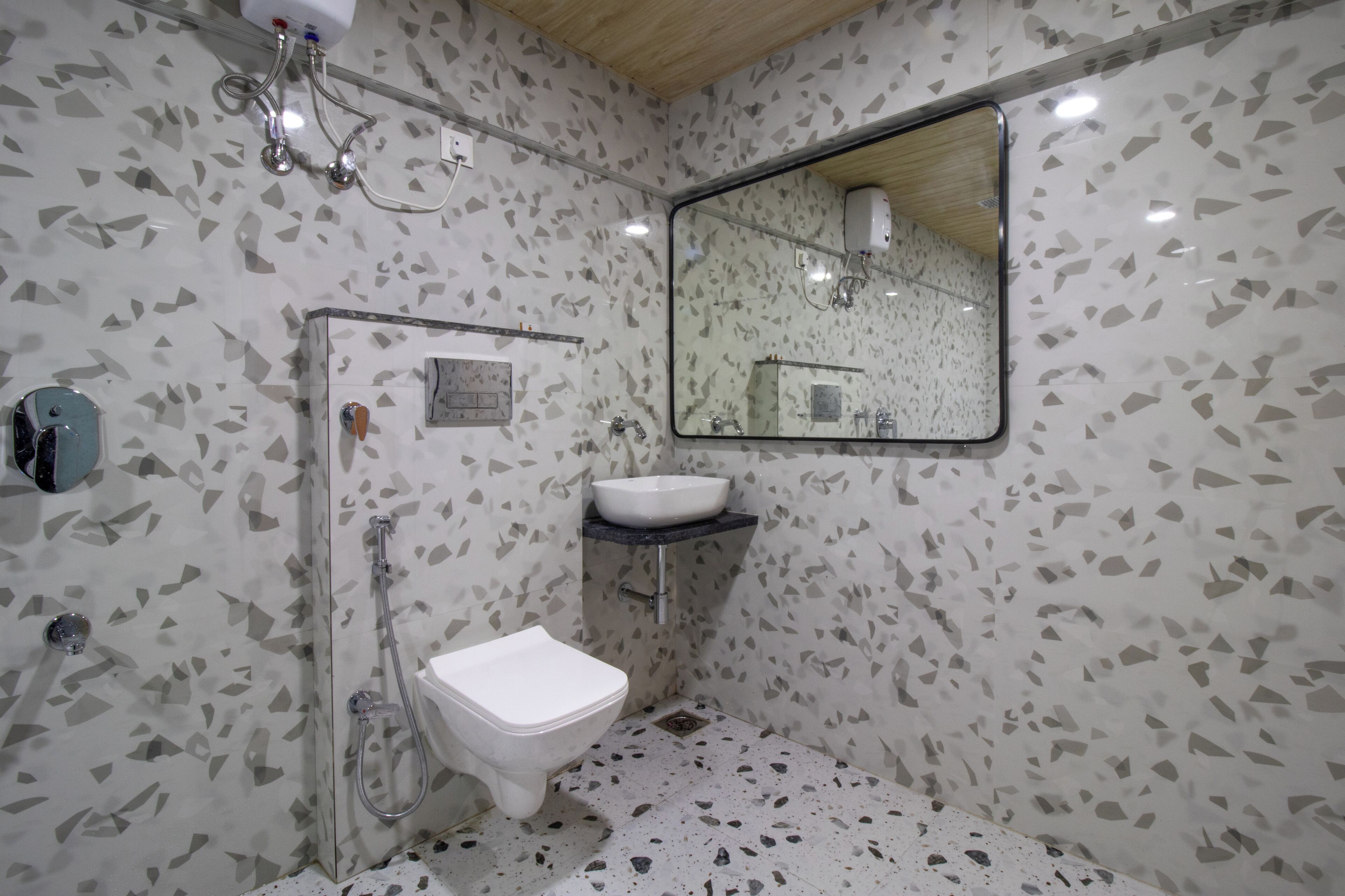Une salle de bain équipée d’une douche, de toilettes, d’un lavabo et d’un miroir.