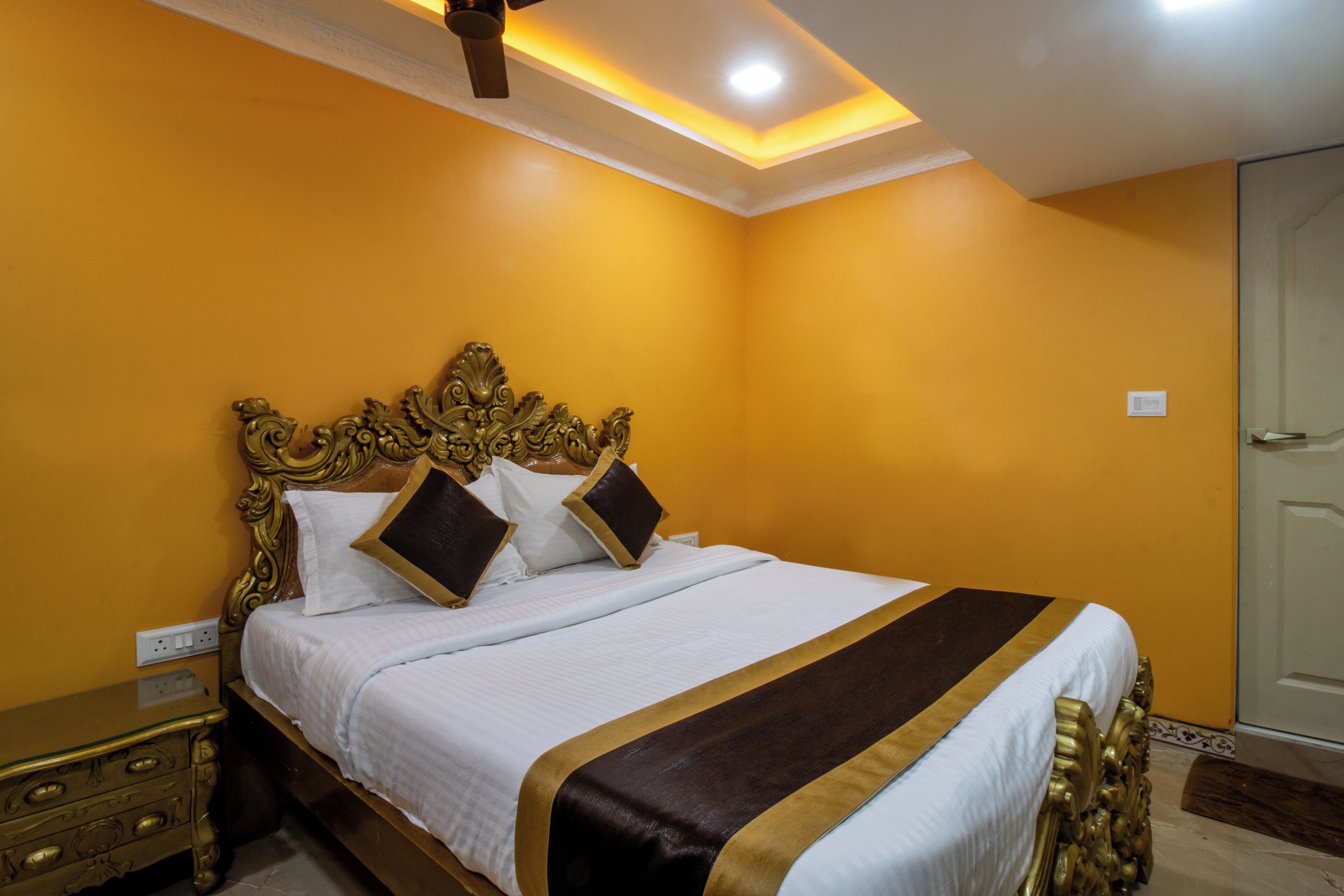 Une chambre d’hôtel avec un grand lit, une tête de lit décorée et une table de chevet.
