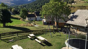 A rural landscape with houses, picnic tables, and a trampoline. - Gîte "le Grand Ferrand" (Saint Etienne en Dévoluy)