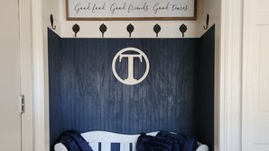 A white bench with a dark blue backdrop and a sign above it that reads "THE GATHERING PLACE".