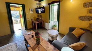 Una sala de estar acogedora con una mesa de madera, un sofá y un televisor montado en la pared.