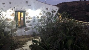 Un edificio rústico de piedra con una puerta de madera y una ventana pequeña.