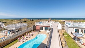 A resort with a swimming pool, beach access, and a view of the ocean.
