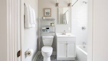 Une petite salle de bain comprenant des toilettes, un lavabo et une baignoire.