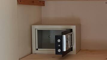 A corner of a room with a white-framed object, possibly a television, on a shelf.