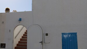 A white building with a blue door and a staircase leading to an upper level. - Sea Foam - 5 people (San José)