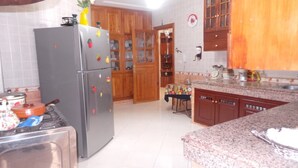 Una cocina con armarios de madera, un refrigerador de acero inoxidable y una encimera de granito.