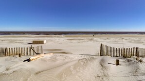 A sandy beach with a wooden fence and a concrete structure. - 503 Barrington Arms - Crisp and Beachy.  What a View! (Hilton Head Island)