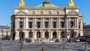 A grand building with classical architecture, featuring columns, statues, and ornate decorations.