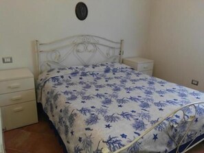 2 dormitorios y tabla de planchar con plancha