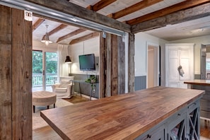 Enjoy cooking in this well-equipped kitchen with a large countertop, cabinetry, and a mounted TV.