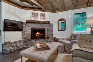 Relax in the living room with a fireplace, flat-screen TV, and comfortable seating.