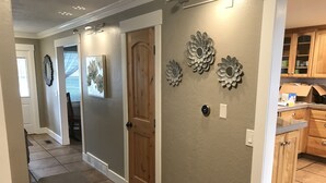 A hallway with a wooden door, a mat, and wall decorations.
