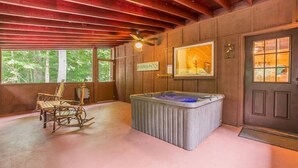 Interior rústico de una cabaña con una mecedora, un jacuzzi y un cartel que dice 'Pumpkin Patch'.