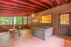 A rustic cabin interior with a rocking chair, a hot tub, and a sign reading 'Pumpkin Patch.'