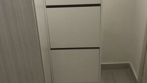 A white wardrobe with three drawers and a black horizontal stripe.