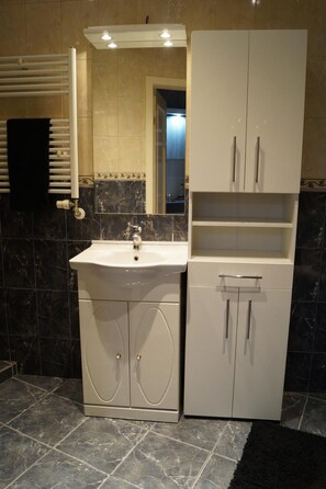 A bathroom with a sink, mirror, and cabinets.