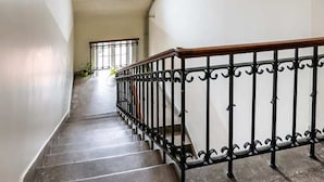 Una scala con ringhiera in metallo che conduce a una stanza con finestra a lucernario.