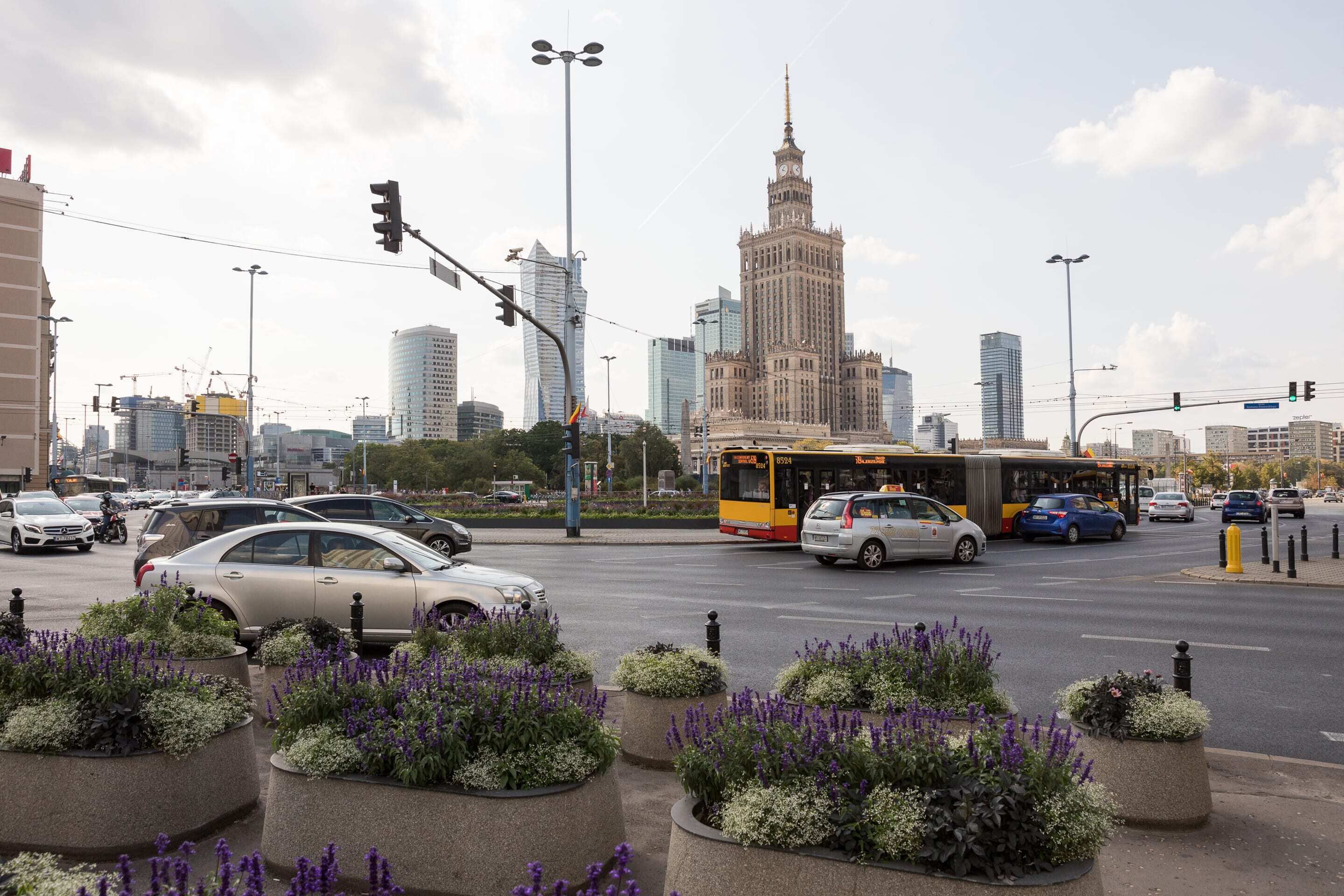 A city intersection with a bus, cars, and traffic lights.