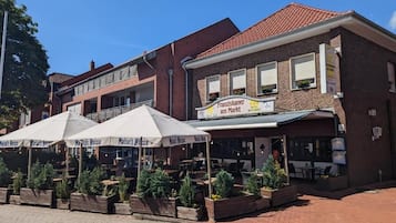 Un restaurant doté d’une terrasse et d’une enseigne indiquant qu’il s’agit également d’une épicerie.