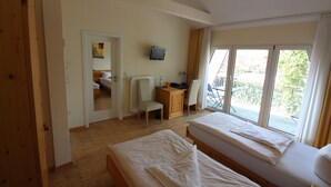 A room with two beds, a desk, a chair, a television, and a view of the outdoors. - Hotel - Restaurant Franziskaner am Markt (Loningen)
