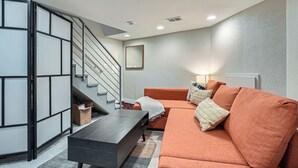 Ein modernes Wohnzimmer mit Treppe, Sofa und Couchtisch.