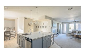 A modern kitchen with a central island, built-in appliances, and pendant lighting. - Beautiful and exceptionally located condo! (Scottsdale)