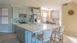 A spacious kitchen with a large island, stainless steel appliances, and pendant lighting. - Beautiful and exceptionally located condo! (Scottsdale)