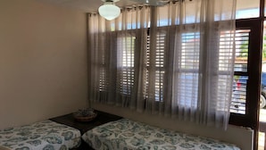 A room with two beds, a ceiling fan, and a window with blinds. - Bahia Sosua 22 (Sosúa)