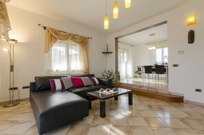 Ein modernes Wohnzimmer mit einer Couch, einem Couchtisch und einem Essbereich mit Stühlen und einem Tisch.