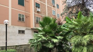 Um edifício de vários andares com fachada de tijolos, aparelhos de ar condicionado e um poste de luz.