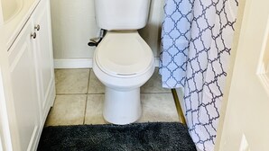 A small bathroom with a toilet, a sink, and a shower curtain. - Views on a Hill..... (San Jose)