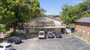 A building with a sign reading "VILLAGE" and a parking lot with several cars.