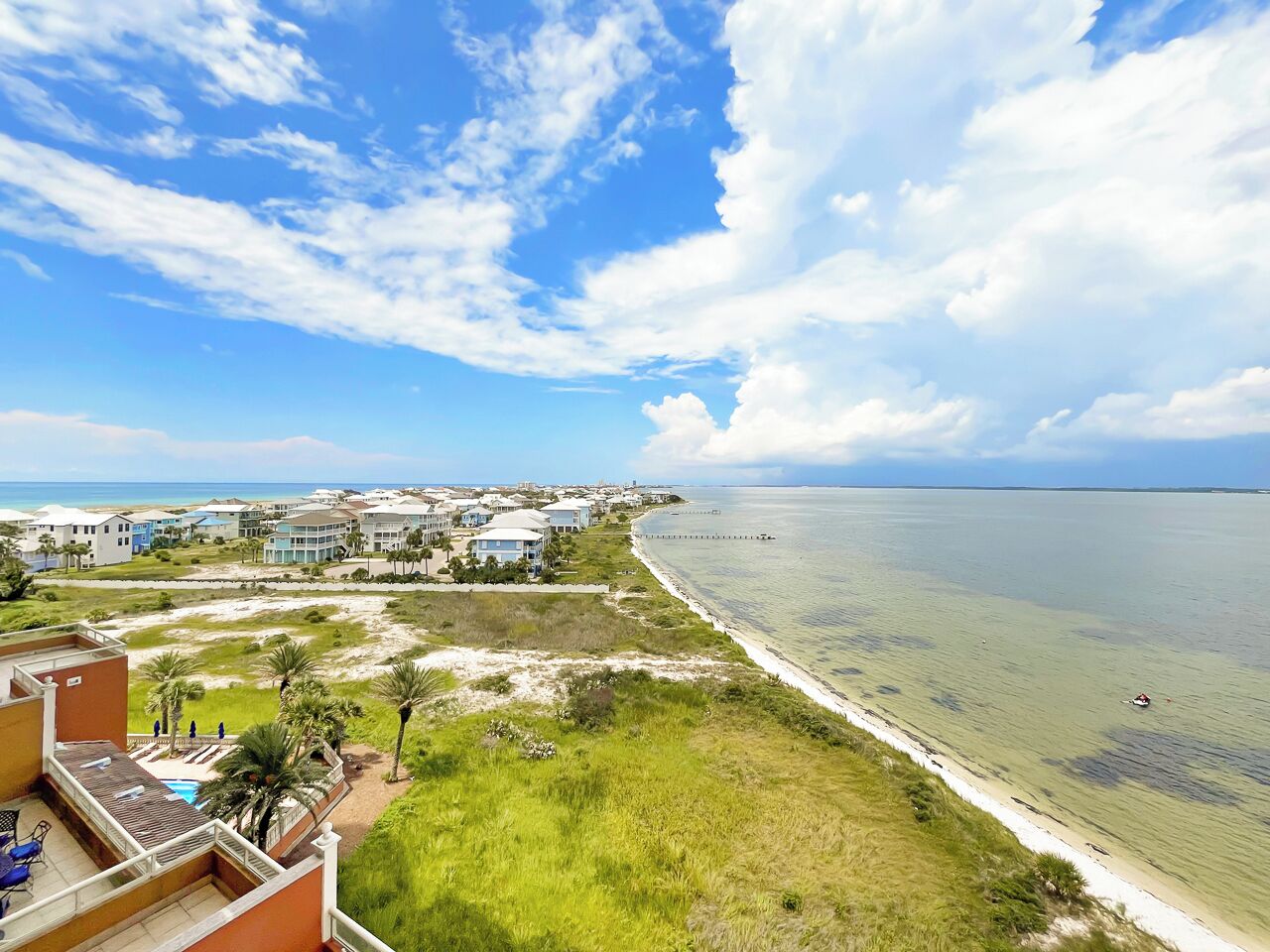 A coastal resort with beachfront properties, a swimming pool, and a view of the ocean.