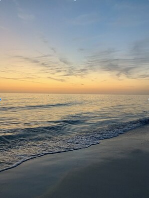 Una playa con olas tranquilas y cielo despejado.