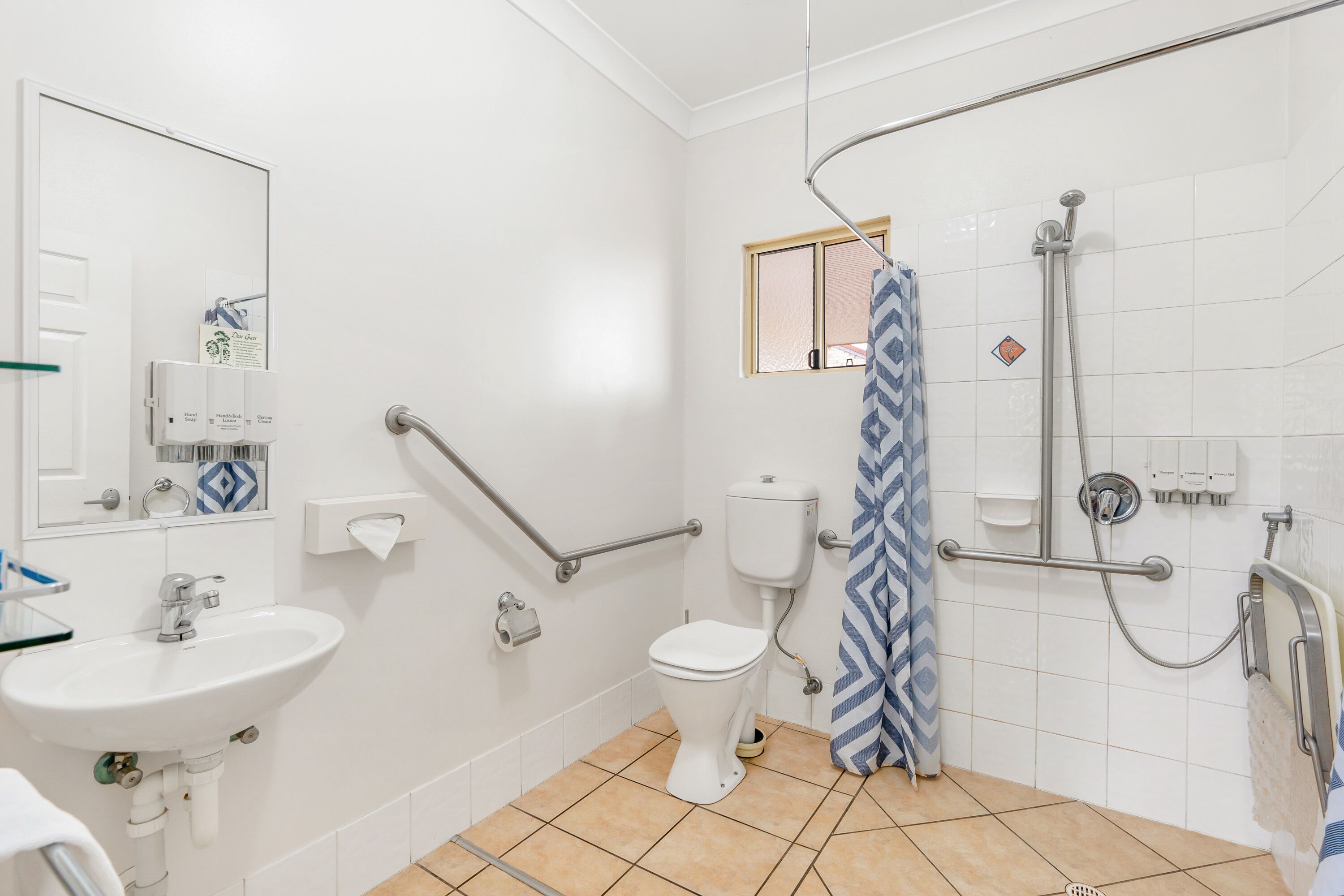 A bathroom with a white sink, toilet, and shower area.