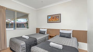 Habitación de hotel con dos camas, un ventanal grande, un cuadro en la pared y vistas al exterior.