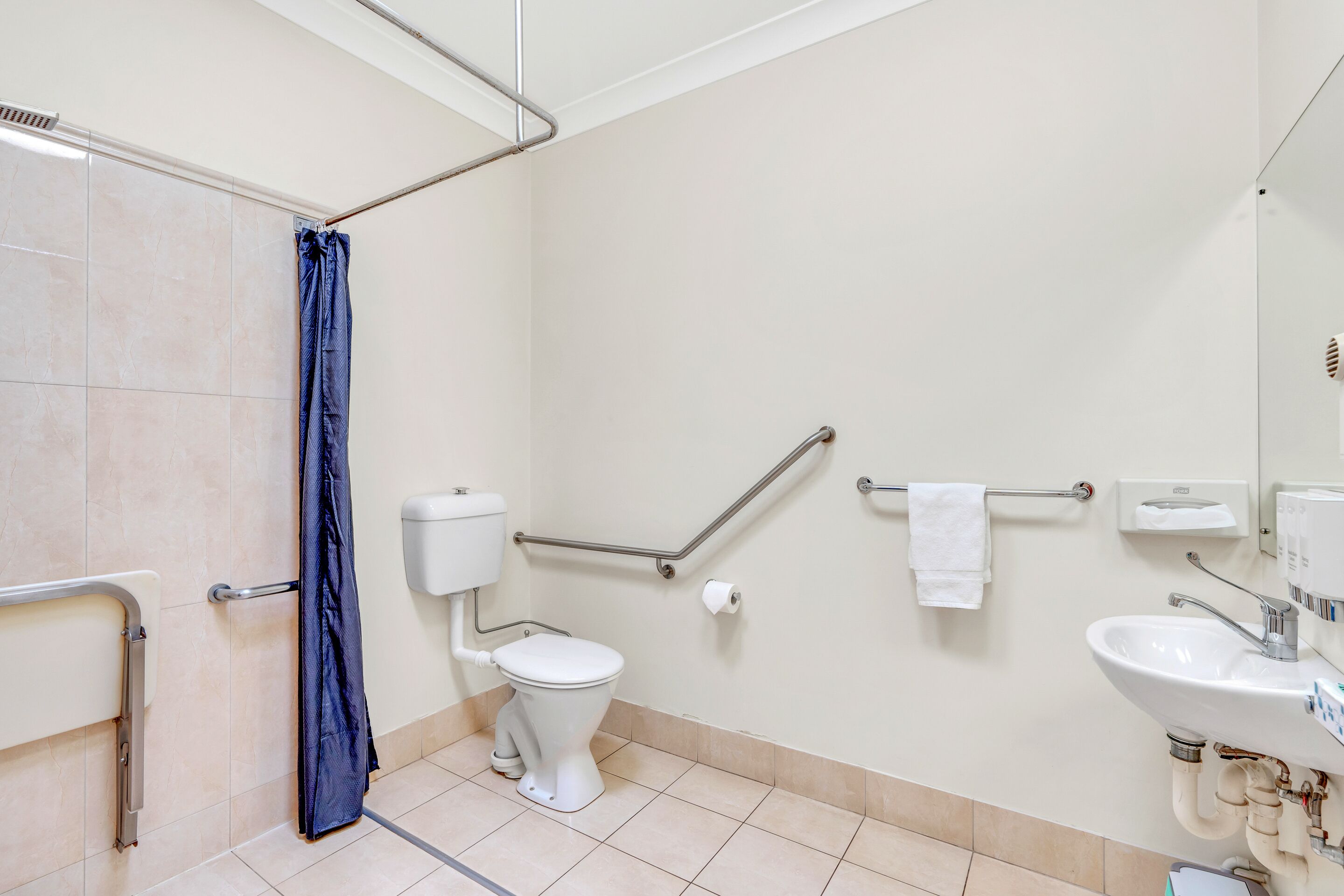 Une salle de bain avec des toilettes, un lavabo et une douche.