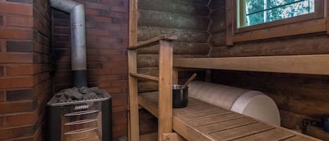Ein rustikales Cabin-Interieur mit Holzofen, einem Fenster mit Aussicht und einem Etagenbett.