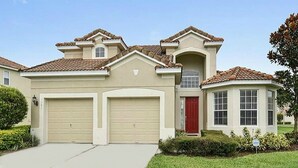 Una casa de dos pisos con fachada color beige, una puerta roja y un garaje.