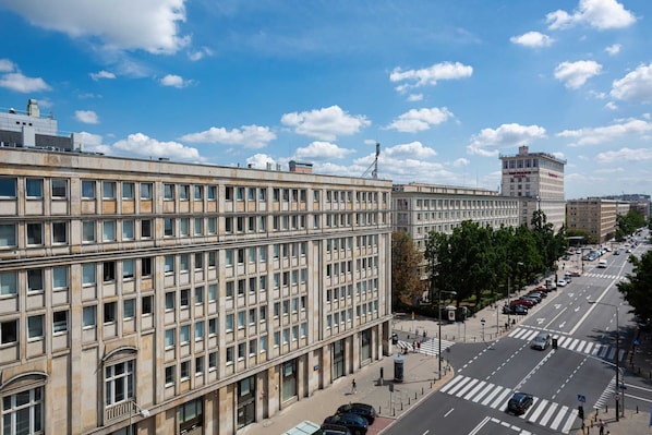 A multi-story building with a grid of windows, a pedestrian crossing, and a clear sky.