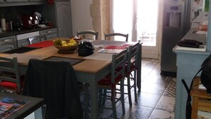 Una cucina con un tavolo da pranzo, sedie e un frigorifero.