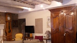 Un soggiorno con un divano, un mobile in legno e un televisore.