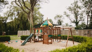 Un parque infantil con tobogán, estructuras para escalar y columpios.
