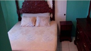 Ein Schlafzimmer mit einem Bett, einer Kommode und einer Tür.