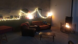 A cozy living room with a sofa, a small table, and a fireplace. - house in farmhouse (saint nectaire)
