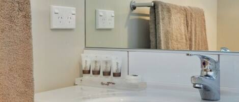 A bathroom with a sink, a towel rack, and a mirror.