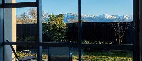 A room with large windows offering a view of snow-capped mountains.